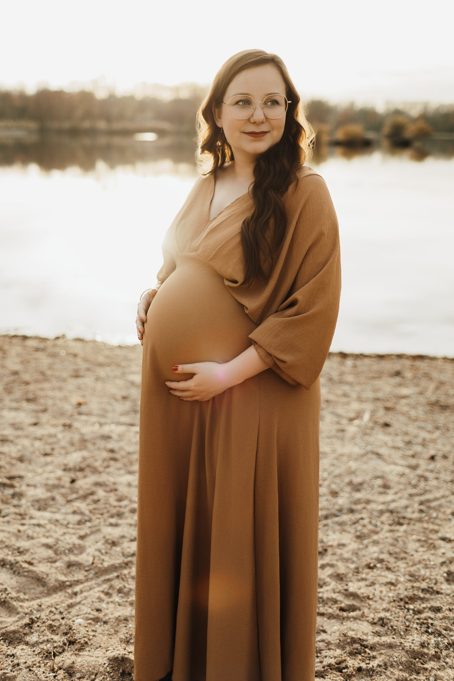 Schwangere Frau bei Babybauchshooting am See