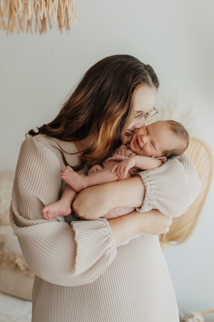 Mama mit Baby auf Arm bei Babyshooting im Studio