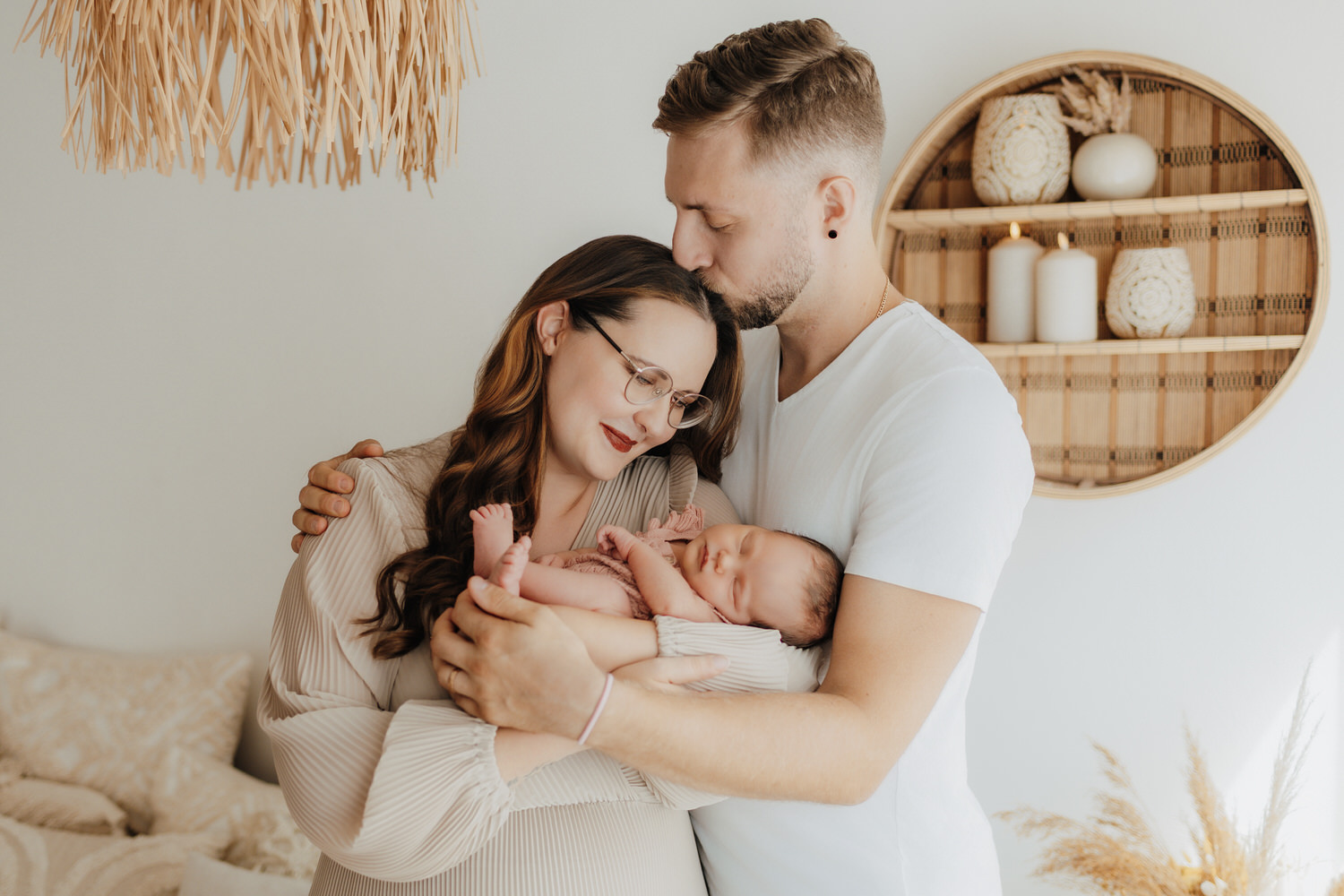 Paar mit Baby im Arm bei Neugeborenenshooting